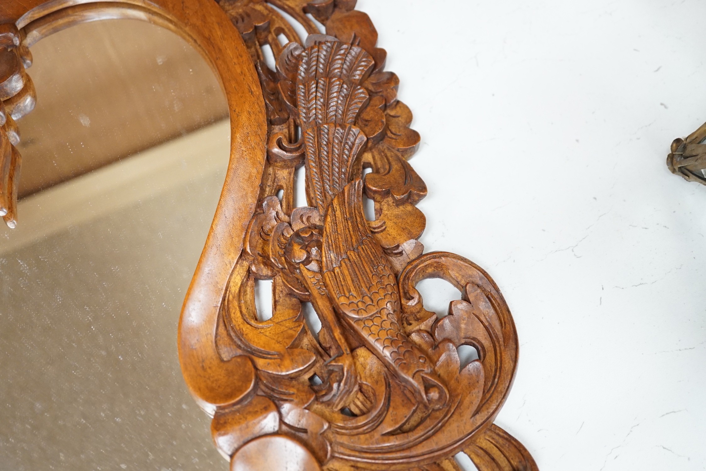A Balinese carved wood wall mirror, 62cm long